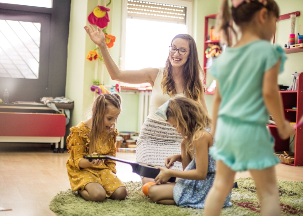 Teacher leads a music activity in circle time with kids.