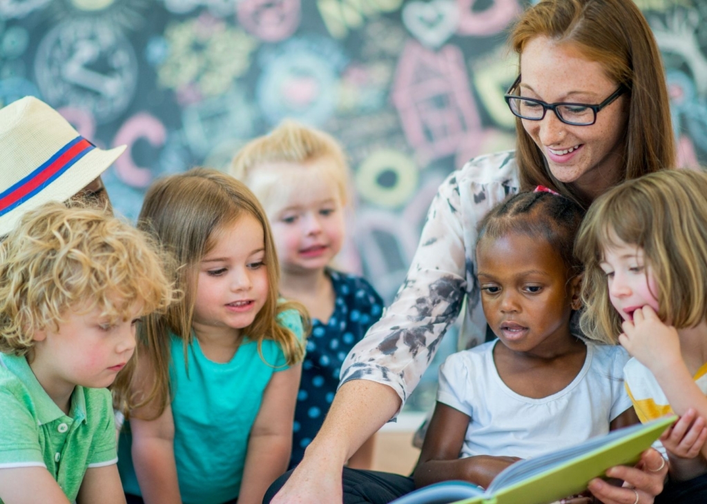 Teach reads to a group of toddlers.