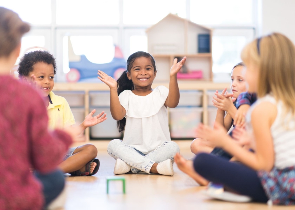 Children play circle time games at preschool.