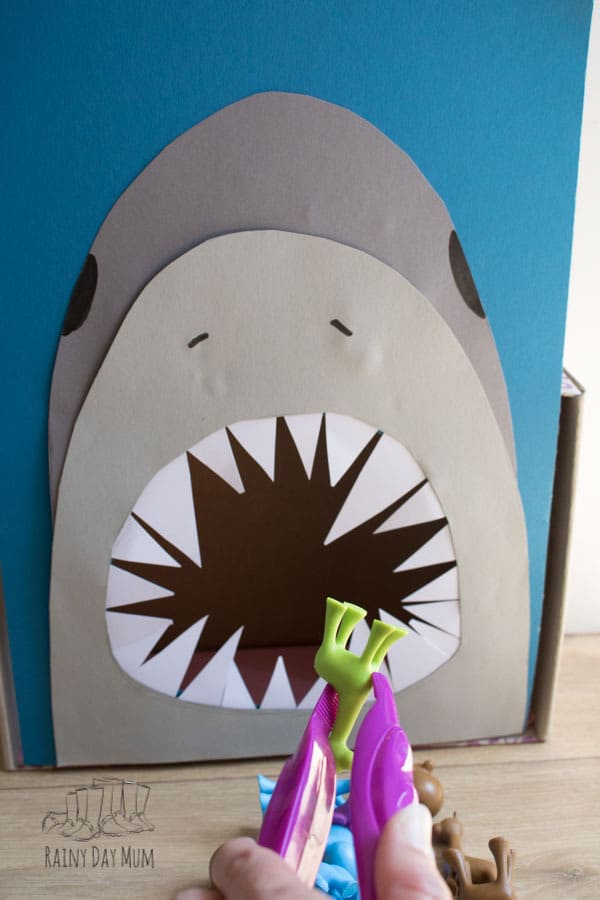 DIY feed the shark preschool math game with a poster board and paper cutouts.