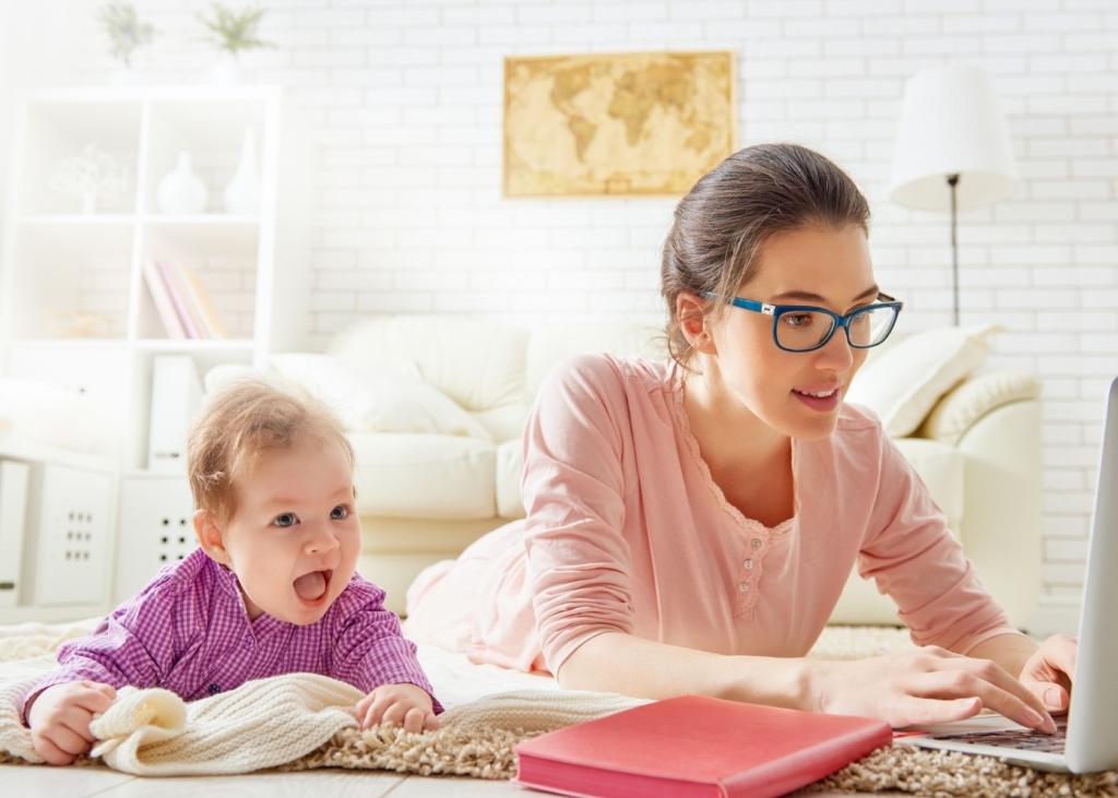 Mom searches on computer for ways to save money with a new baby as an influencer.