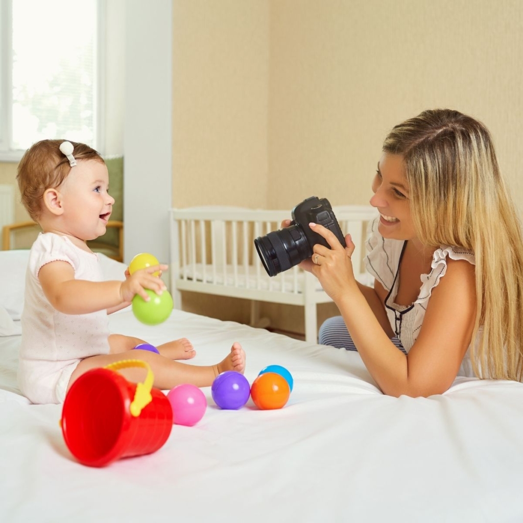 Mom taking pictures of baby at an at-home photo shoot.