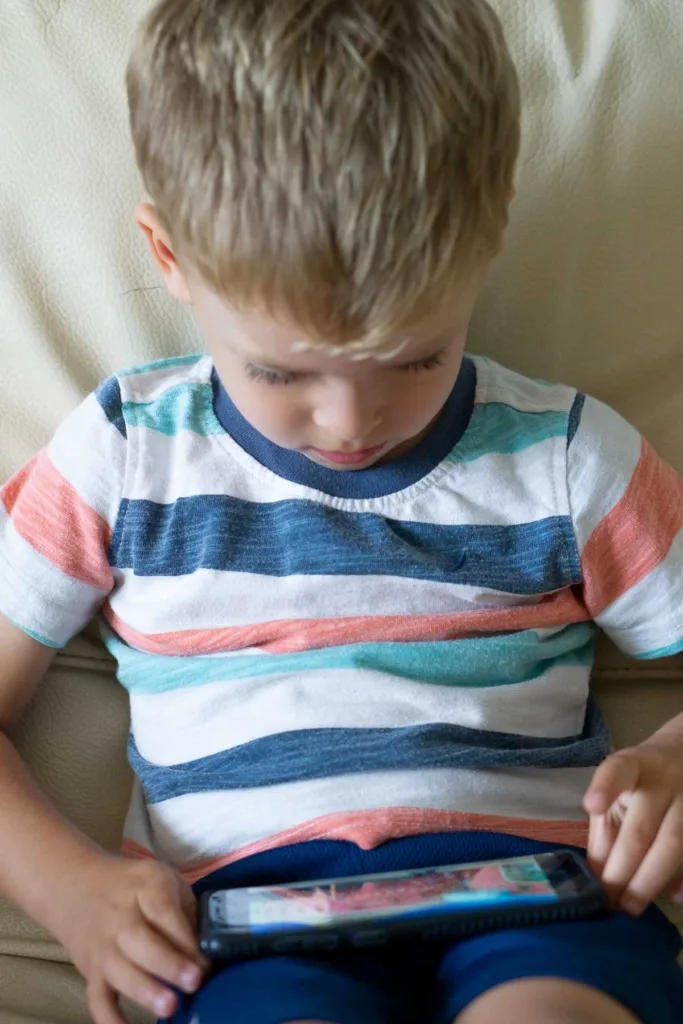 Preschooler watching spanish show on the phone.