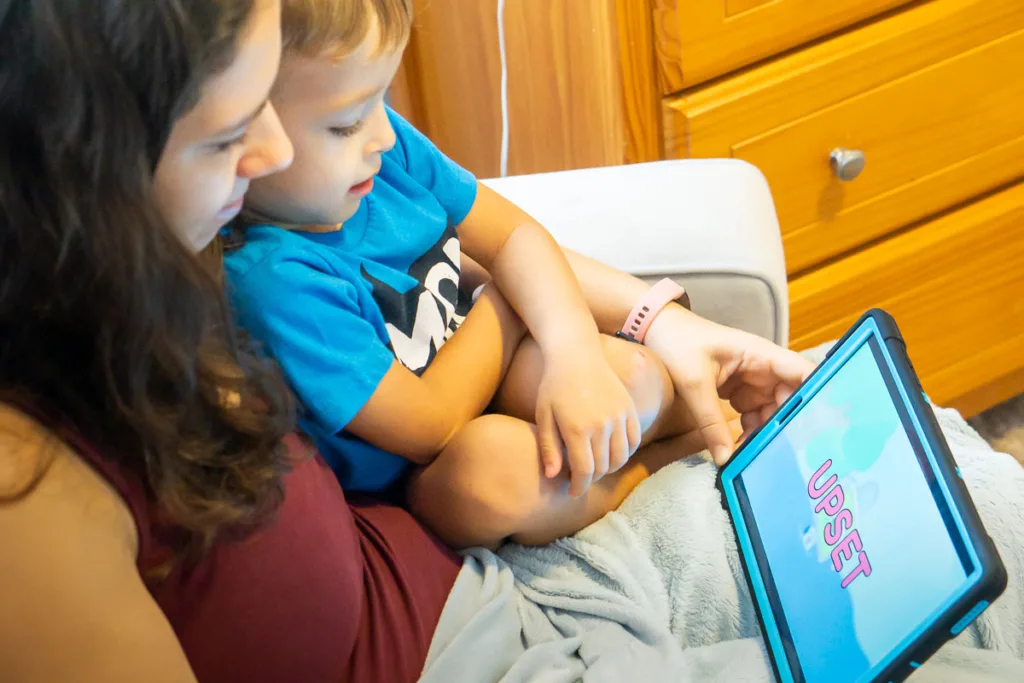 Mom and boy watching a tablet and learning about emotions.