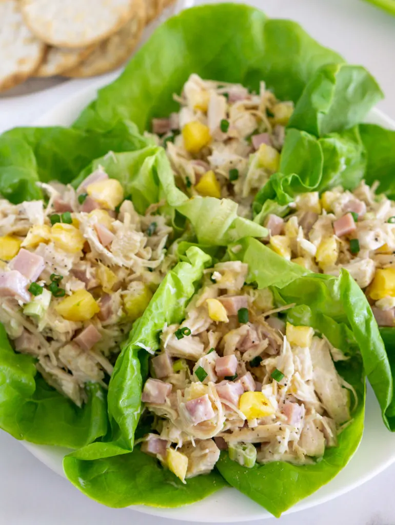 Chicken salad with pineapple and ham in lettuce wraps.