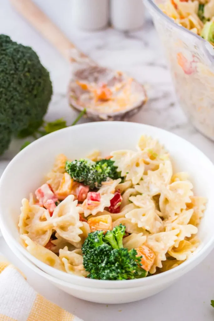 Broccoli ranch pasta salad with bell peppers in a white bowl.