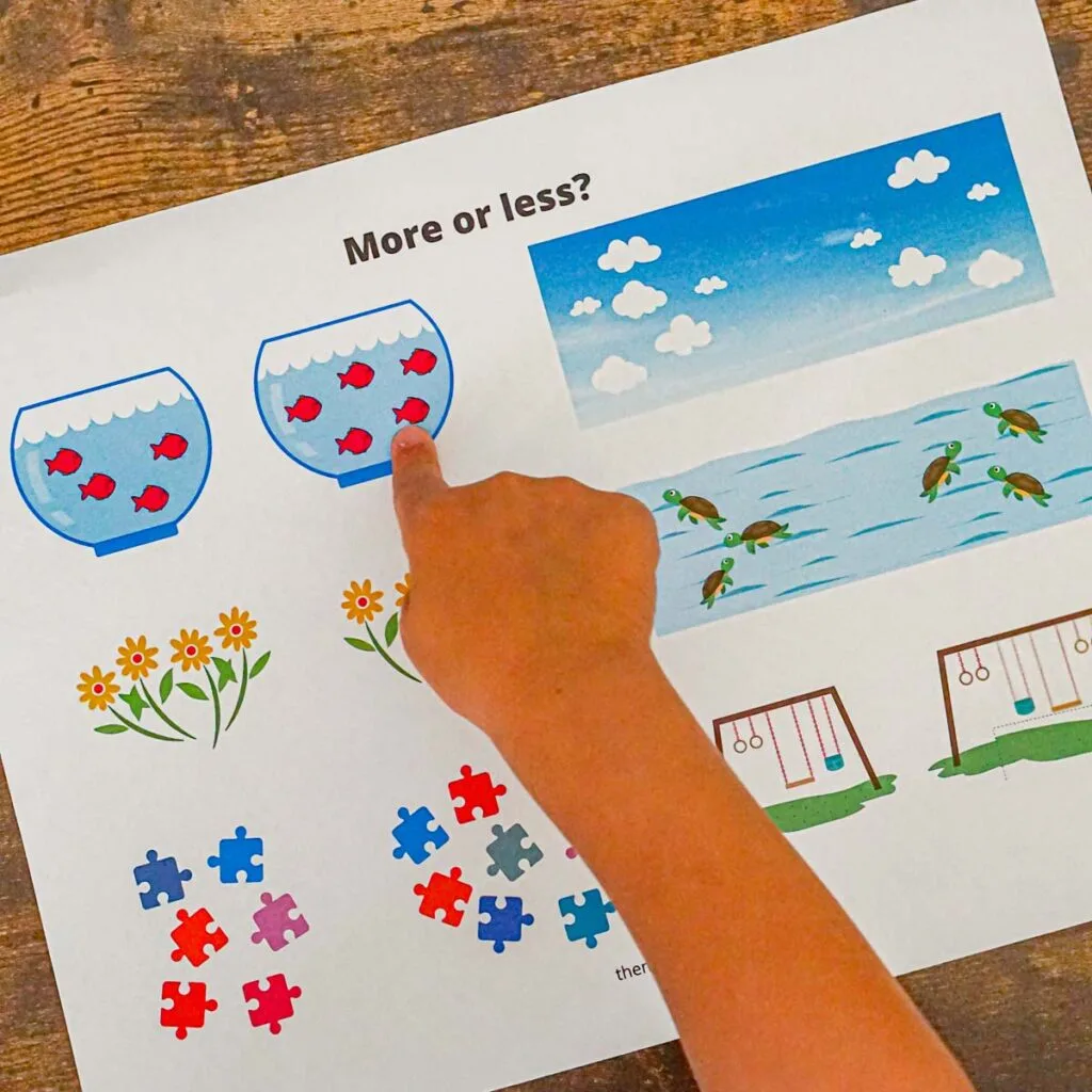 Toddler pointing at a math worksheet with pictures of items to guess "more or less?"