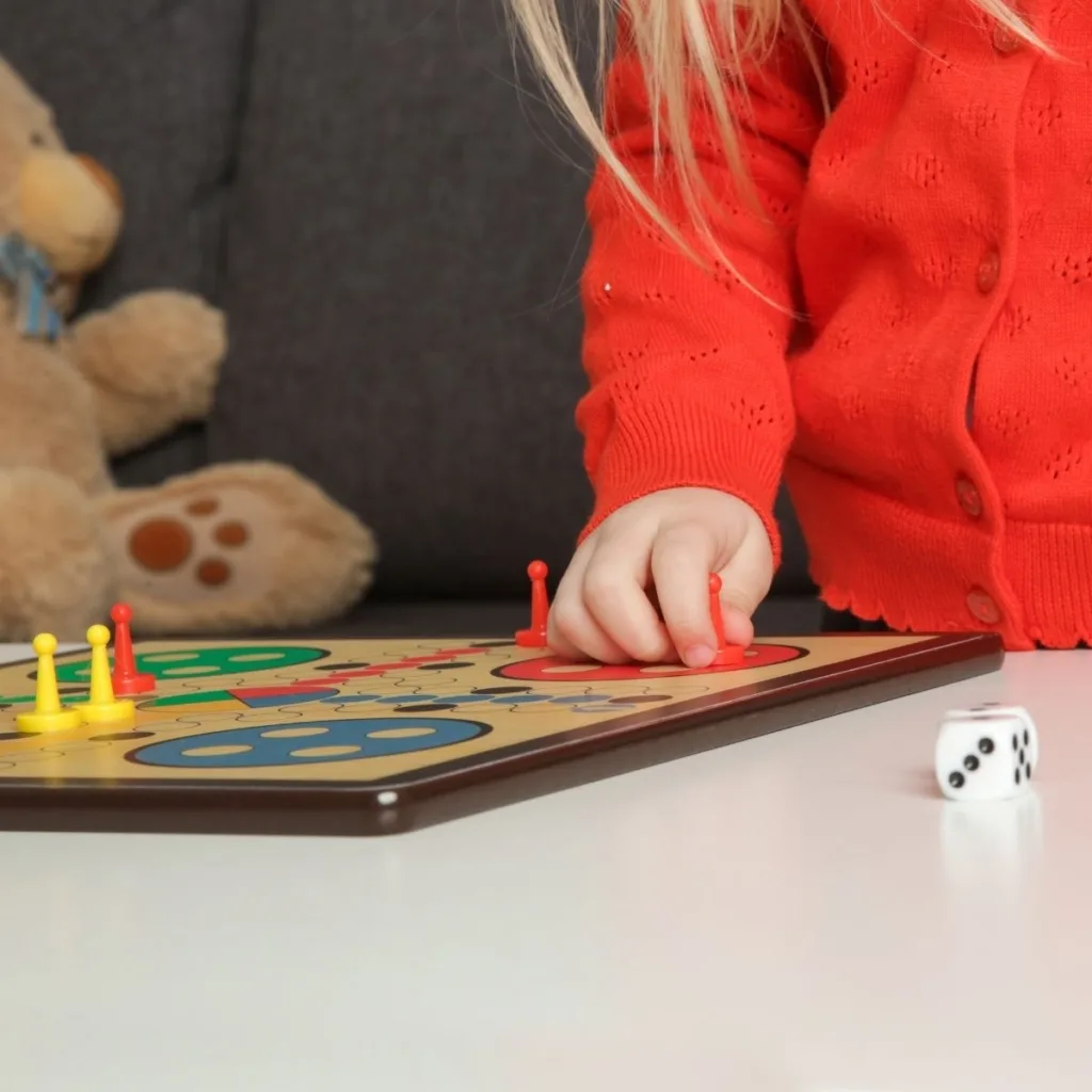 Close up picture of a preschool girl playing a board game. 