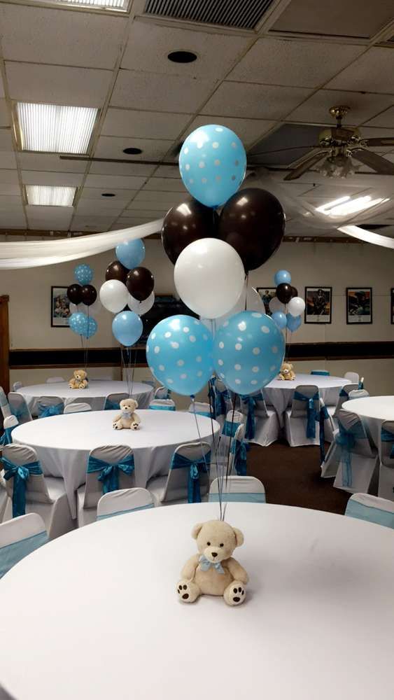 Blue balloons tied to small teddy bear