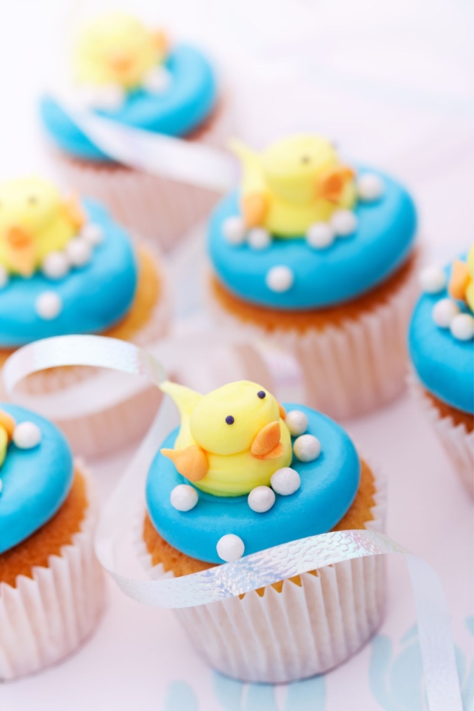 Cupcakes with blue icing and fondant ducks on top.