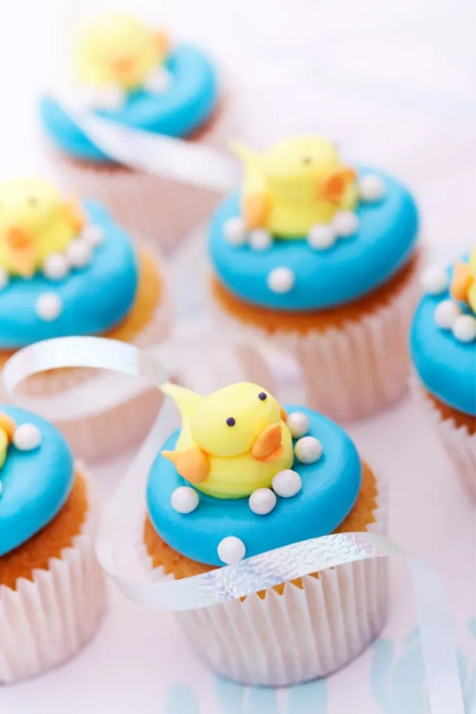 Cupcakes with blue icing and fondant ducks on top.