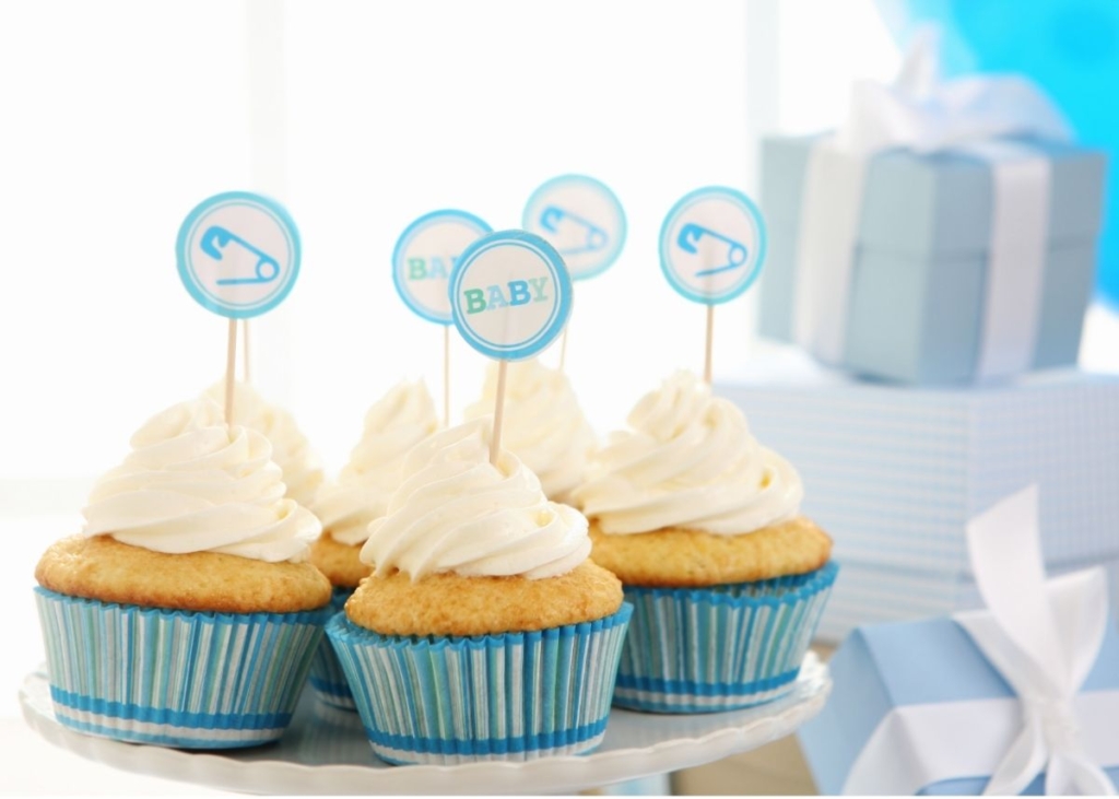 Cupcakes with white frosting and blue baby shower cupcake toppers.
