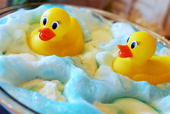 Baby ducks floating in frothy blue drink