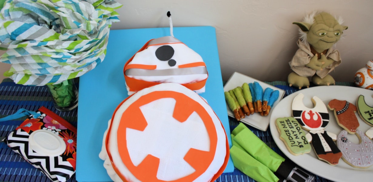 Star Wars BB-8 diaper cake next to Star Wars-themed baby shower cookies.